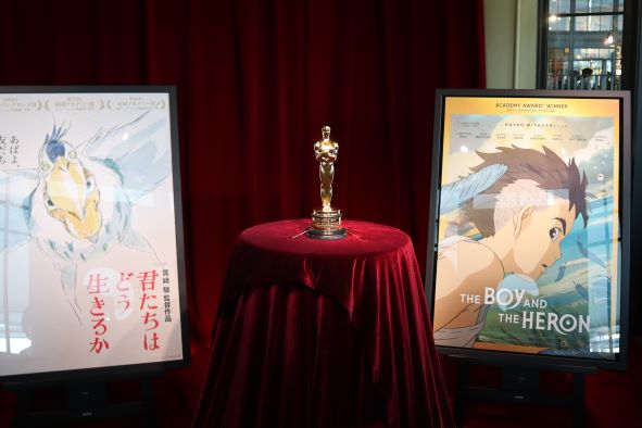 アカデミー賞長編アニメーション映画部門賞のオスカー像と『君たちはどう生きるか』のポスター