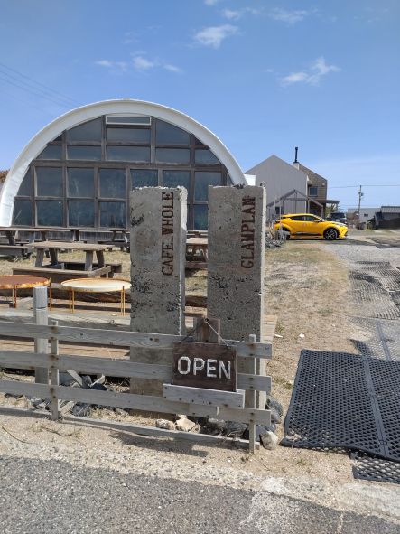 海沿いの道路から見た「Whole cafe」の外観と駐車場